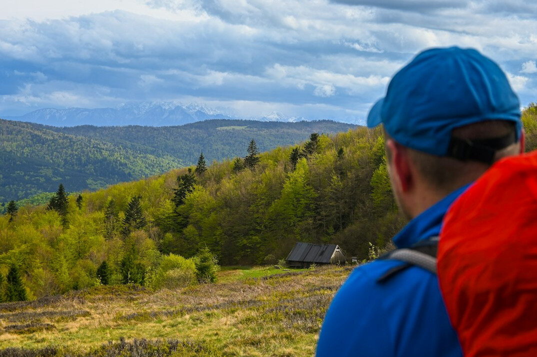 Hiker with map and backpack planning a route on a mountain trail in Poland